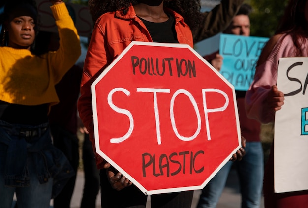 Close up activists protesting with stop sign