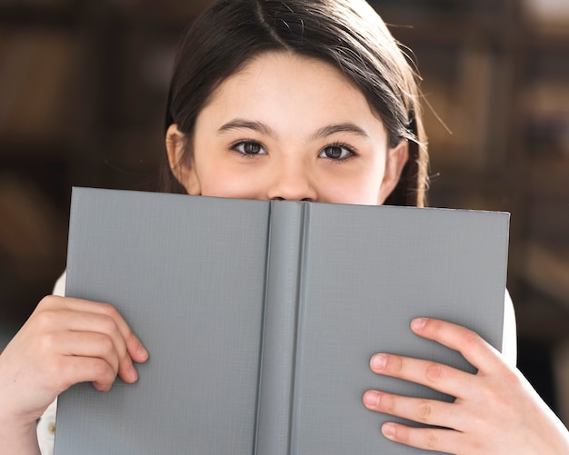 Bambina adorabile del primo piano che tiene un libro