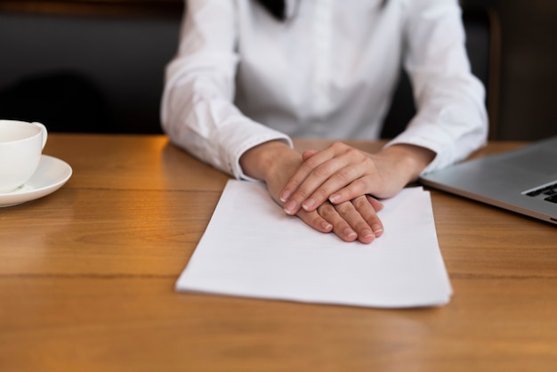 Close-up adult holding hands on papers