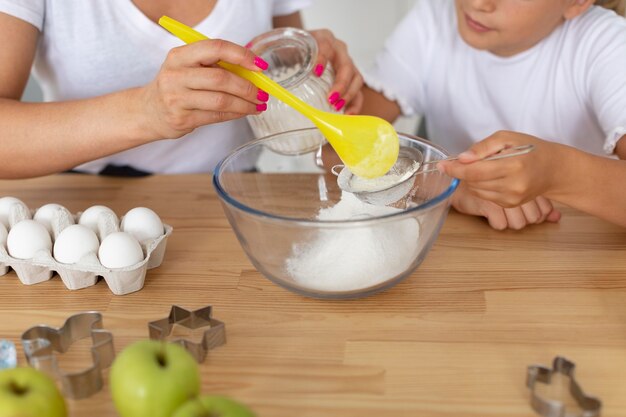 Close up adult and kid cooking together