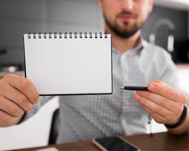 Close-up adult male holding notepad