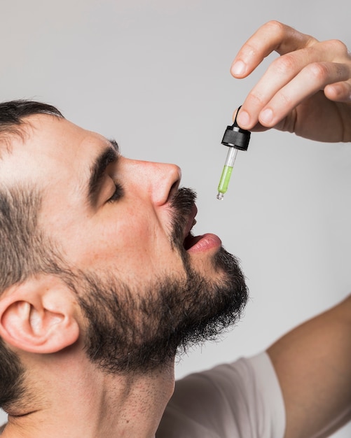 Close-up adult male swallowing drops