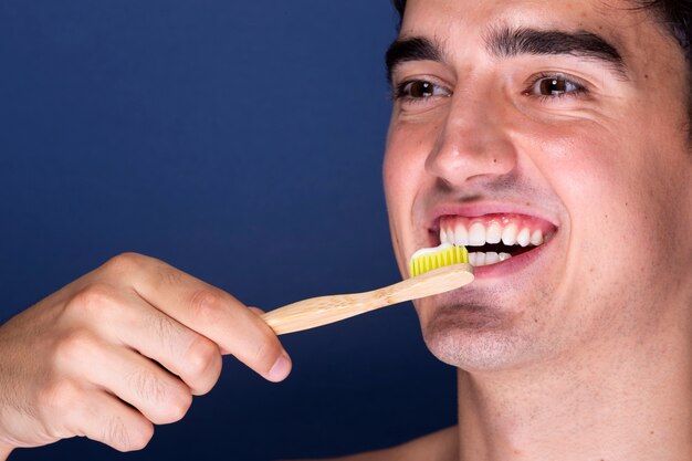 Close-up adult male using toothbrush