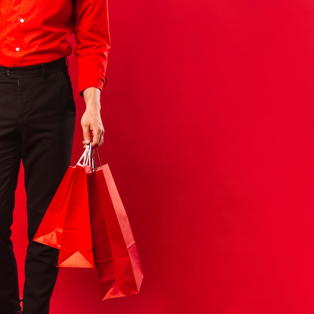 Close-up adult man holding shopping bags