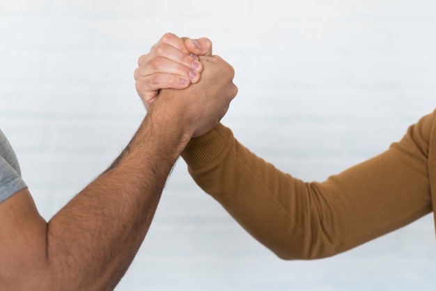 Close-up adult men holding hands