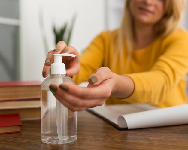 Close-up adult woman disinfecting hands