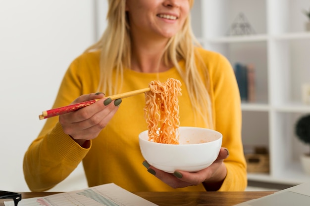 Close-up adult woman eating noodles