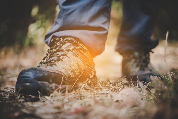 Close up of adventure man feet walk on a mountain path.