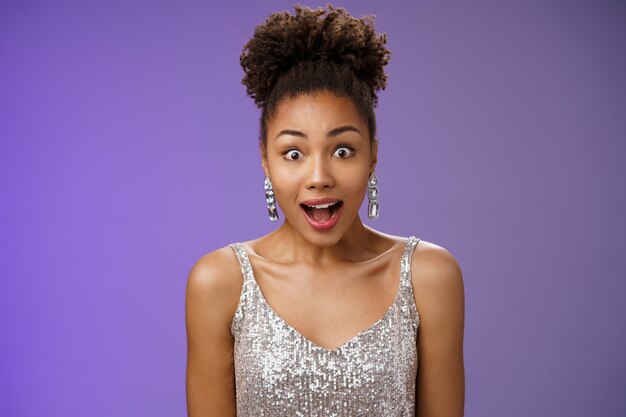 Close-up african-american impressed speechless young girl open mouth surprised gasping widen eyes astonished glancing impressed receive interesting amusing proposal, standing blue background.