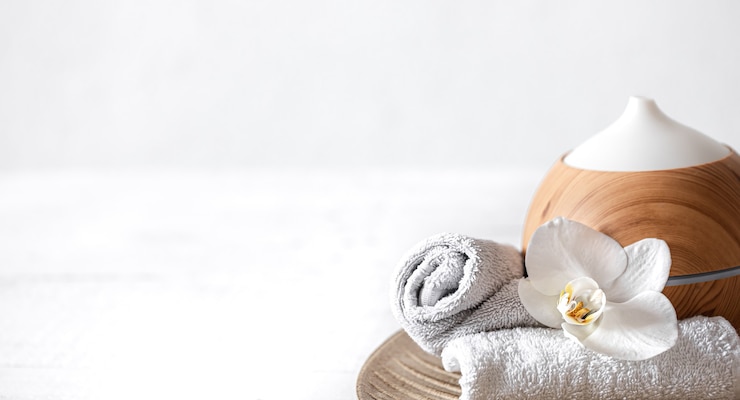 Free Photo close up of air humidifier, towel and orchid flower. 