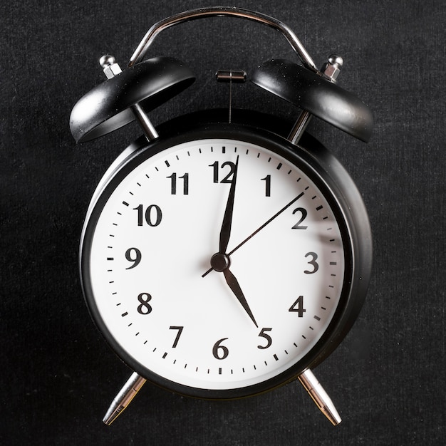 Close-up of an alarm clock on black background