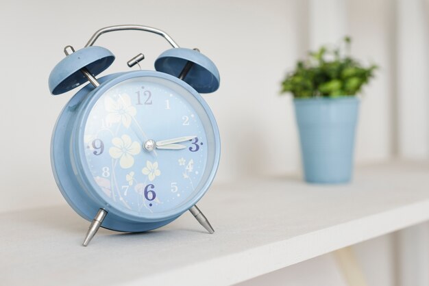 Close-up alarm clock in bookshelf