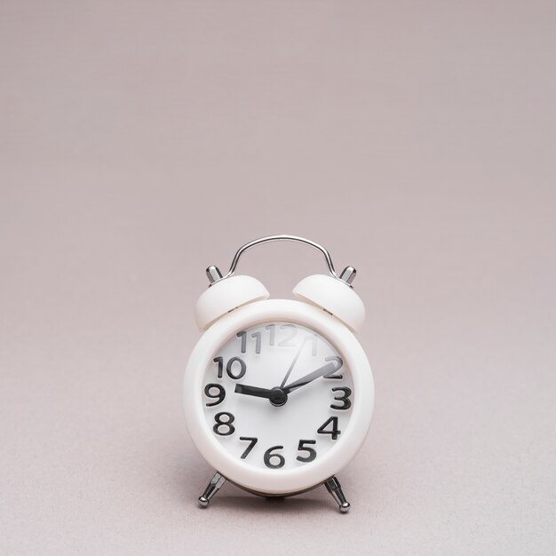 Close-up of alarm clock on colored background