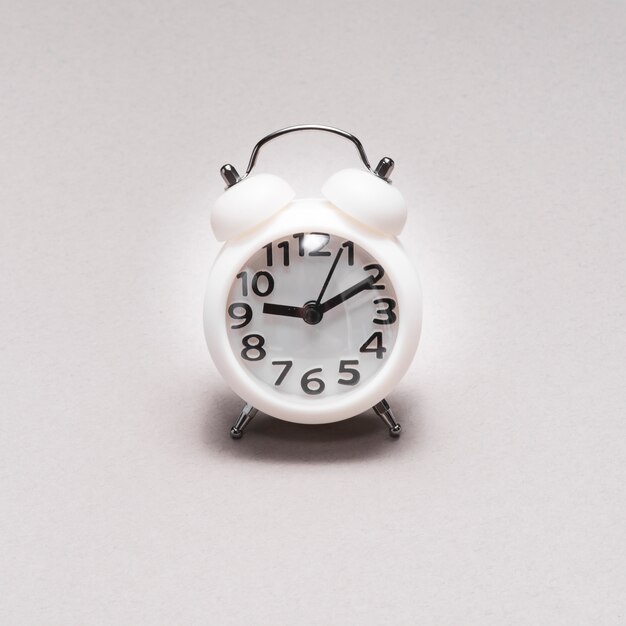 Close-up of an alarm clock on plain background