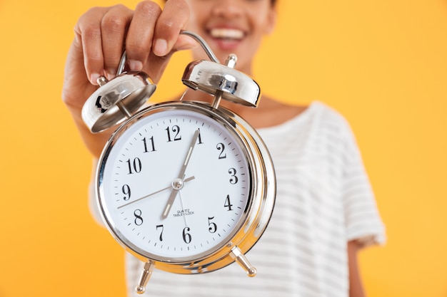 Close up of alarm clock in woman's hand isolated