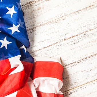 Close-up of an american usa flag with stars and stripes on white plank backdrop