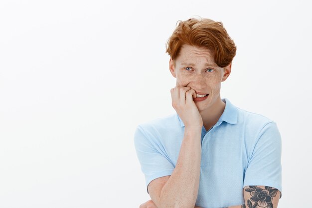 Close-up of anxious indecisive redhead man worrying about something, looking upper left corner