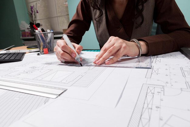 Close up of architect hands working on blueprints. Business and creativity. Architecture job