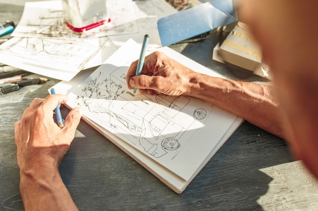 Free photo close up of architect sketching a construction project on his plane project