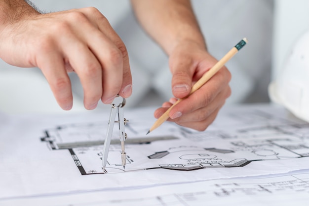 Архитектор крупным планом с помощью компаса и карандаша