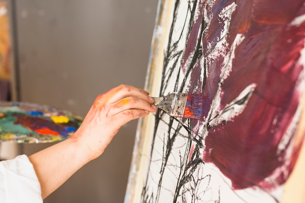 Close-up of artist hand painting with paintbrush