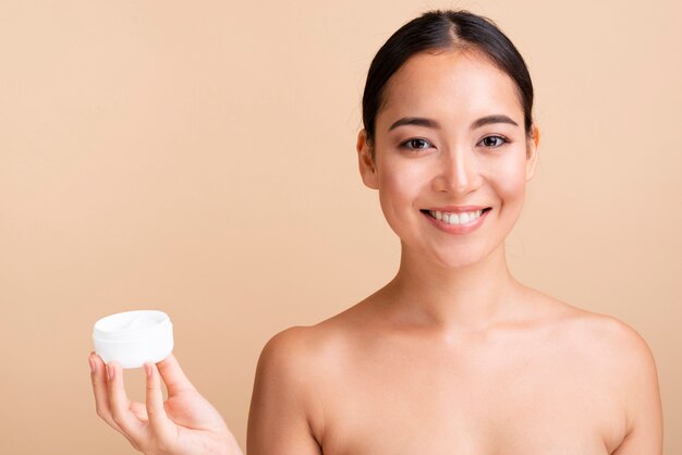 Close-up asian woman holding cream jar