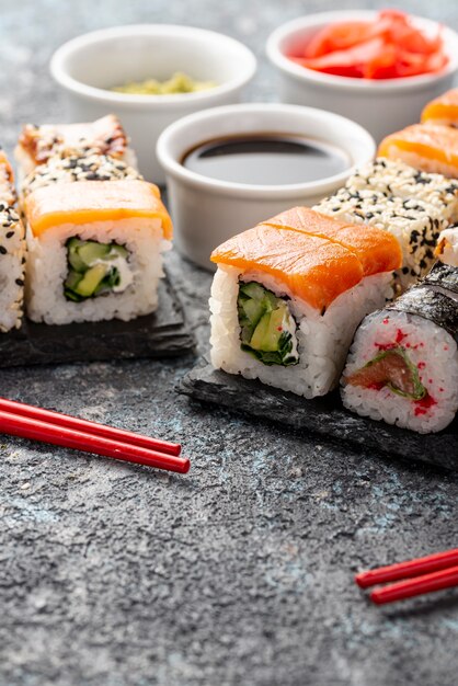 Close-up assortment of maki sushi rolls with chopsticks