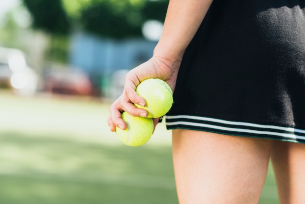 Close-up of athlete woman holding tennis balls