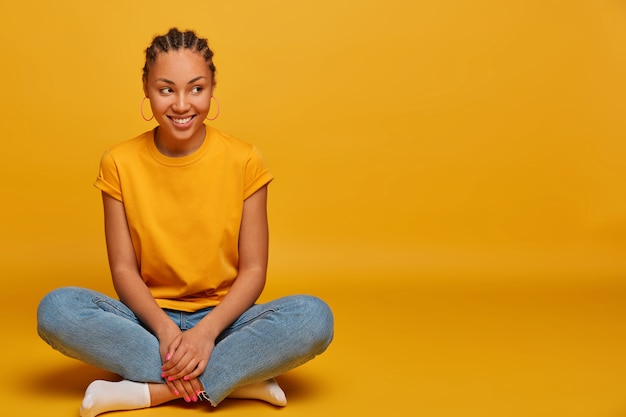 Free photo close up on attractive carefree young woman sitting on the floor