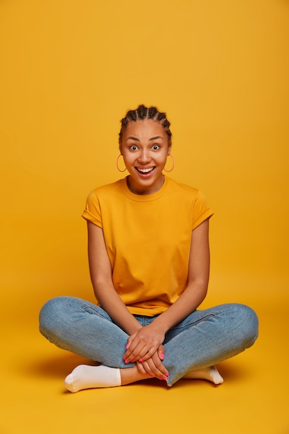 Close up on attractive carefree young woman sitting on the floor