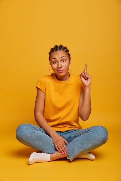 Close up on attractive carefree young woman sitting on the floor