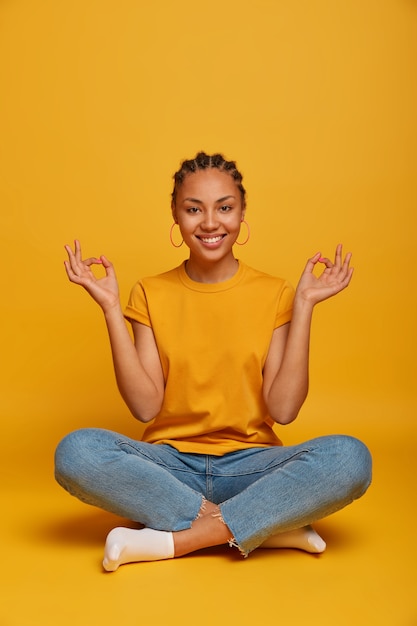 Close up on attractive carefree young woman sitting on the floor