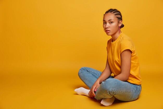 Close up on attractive carefree young woman sitting on the floor