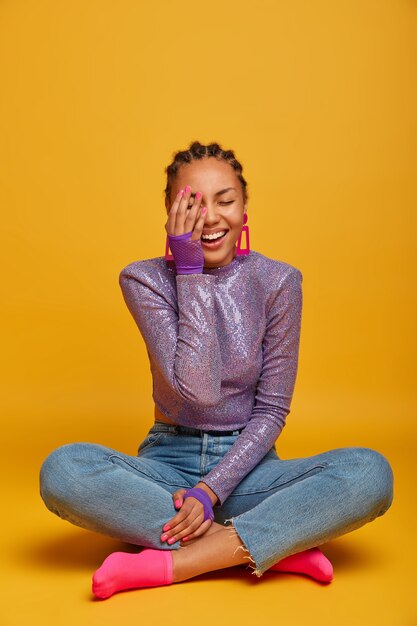 Close up on attractive carefree young woman sitting on the floor