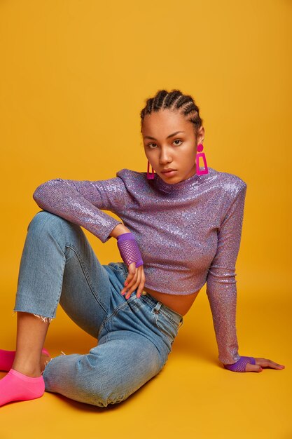 Close up on attractive carefree young woman sitting on the floor