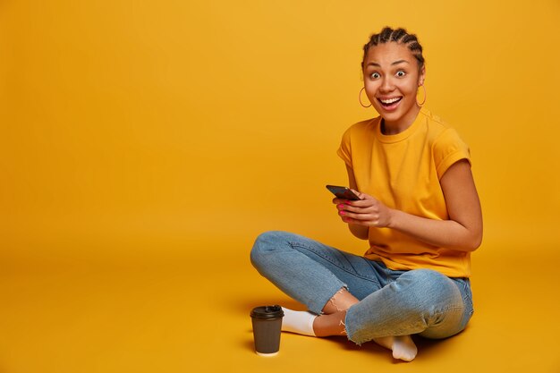 Close up on attractive carefree young woman sitting on the floor