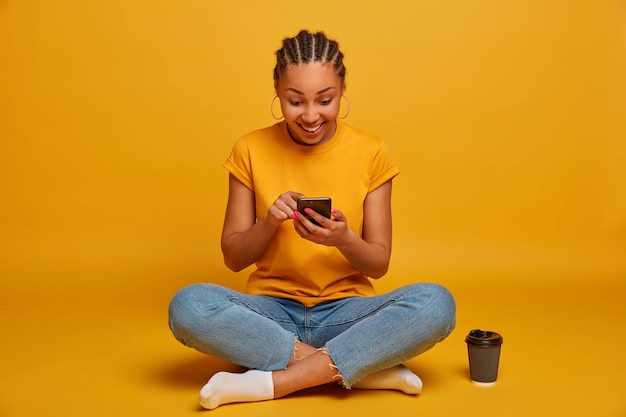 Close up on attractive carefree young woman sitting on the floor