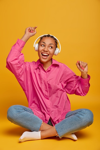 Close up on attractive carefree young woman sitting on the floor