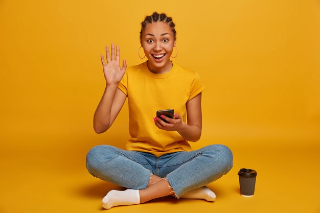 Close up on attractive carefree young woman sitting on the floor