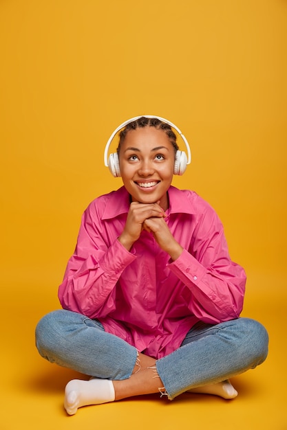 Free photo close up on attractive carefree young woman sitting on the floor