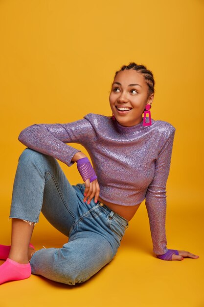 Close up on attractive carefree young woman sitting on the floor