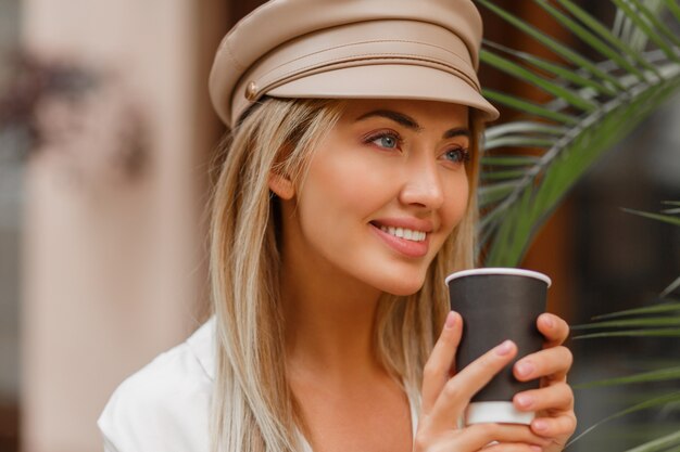 Close up  autumn portrait of romantic  blond woman enjoying hot coffee outdoor