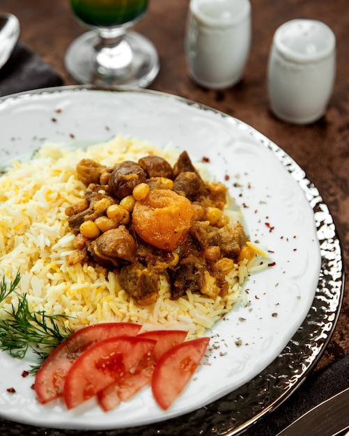 Close up of azerbaijani rice pilov topped with cooked lamb and dried fruits