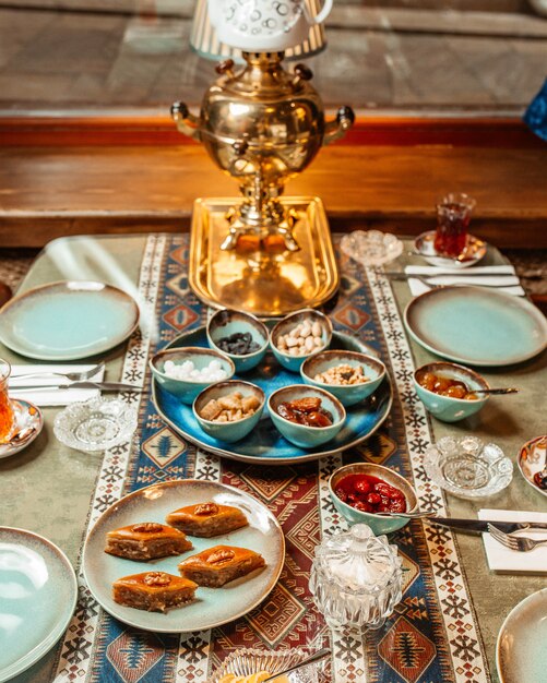 Close up azerbaijani tea setup with pakhlava samovar jams and nuts