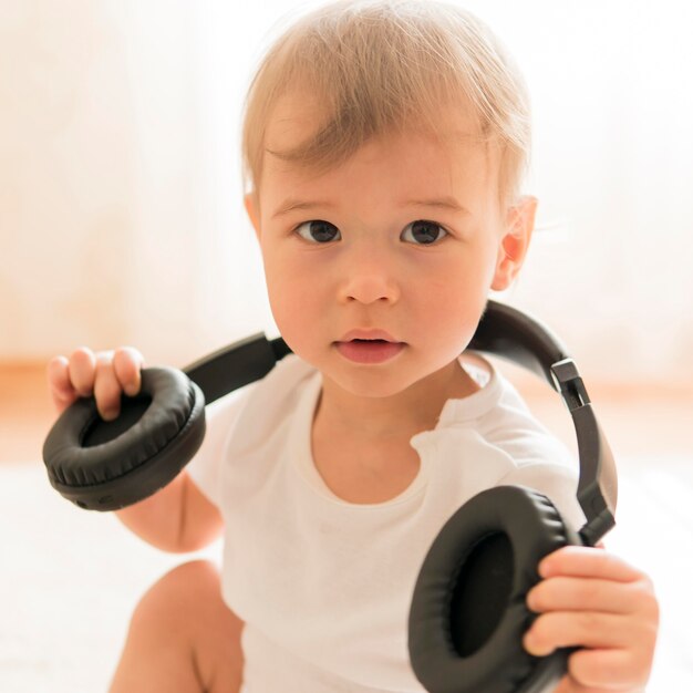Close-up baby holding headphones