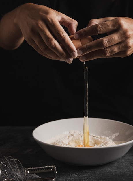 Free photo close-up baker hand mixing flour with egg