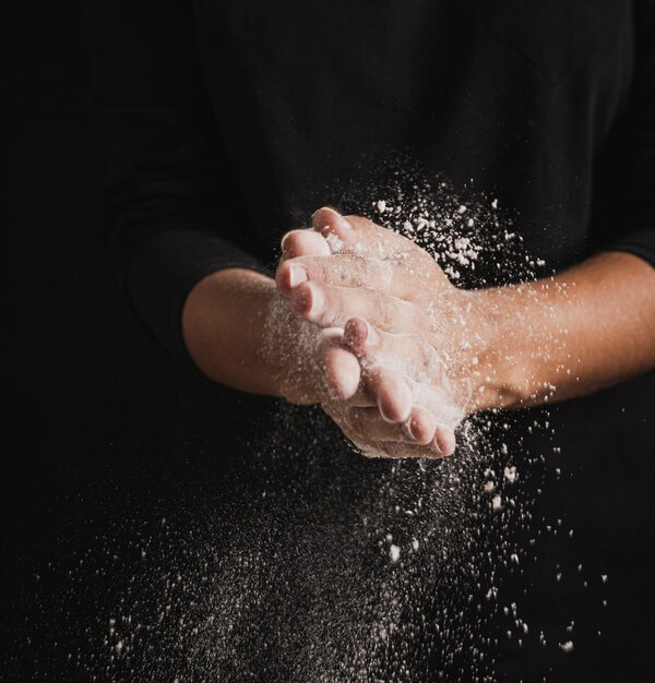 Close-up baker hands full of flour