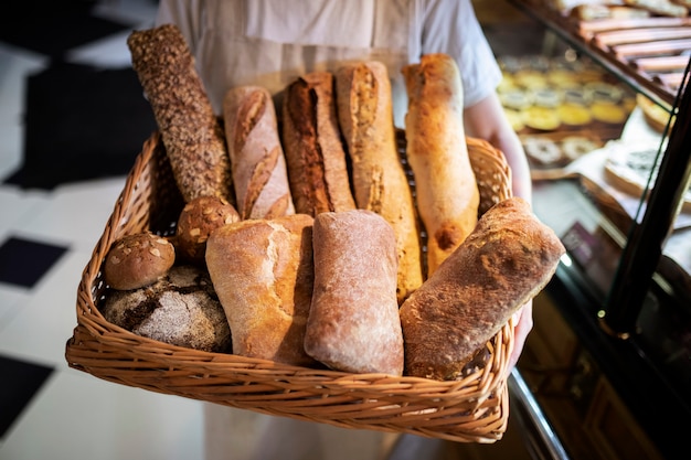Close up baker holding basket with bread sticks