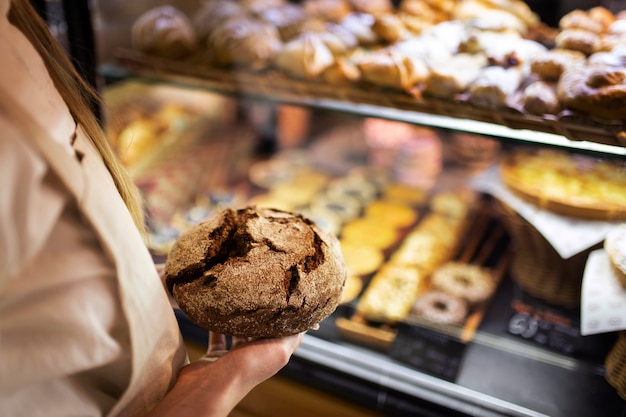 Close up baker holding bread