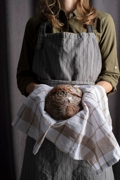 close up baker holding bread